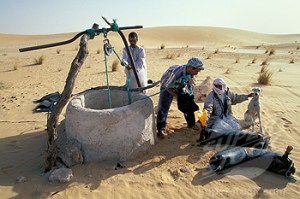 Algeria Touggourt Bedouin men taking water from well Sahara Desert